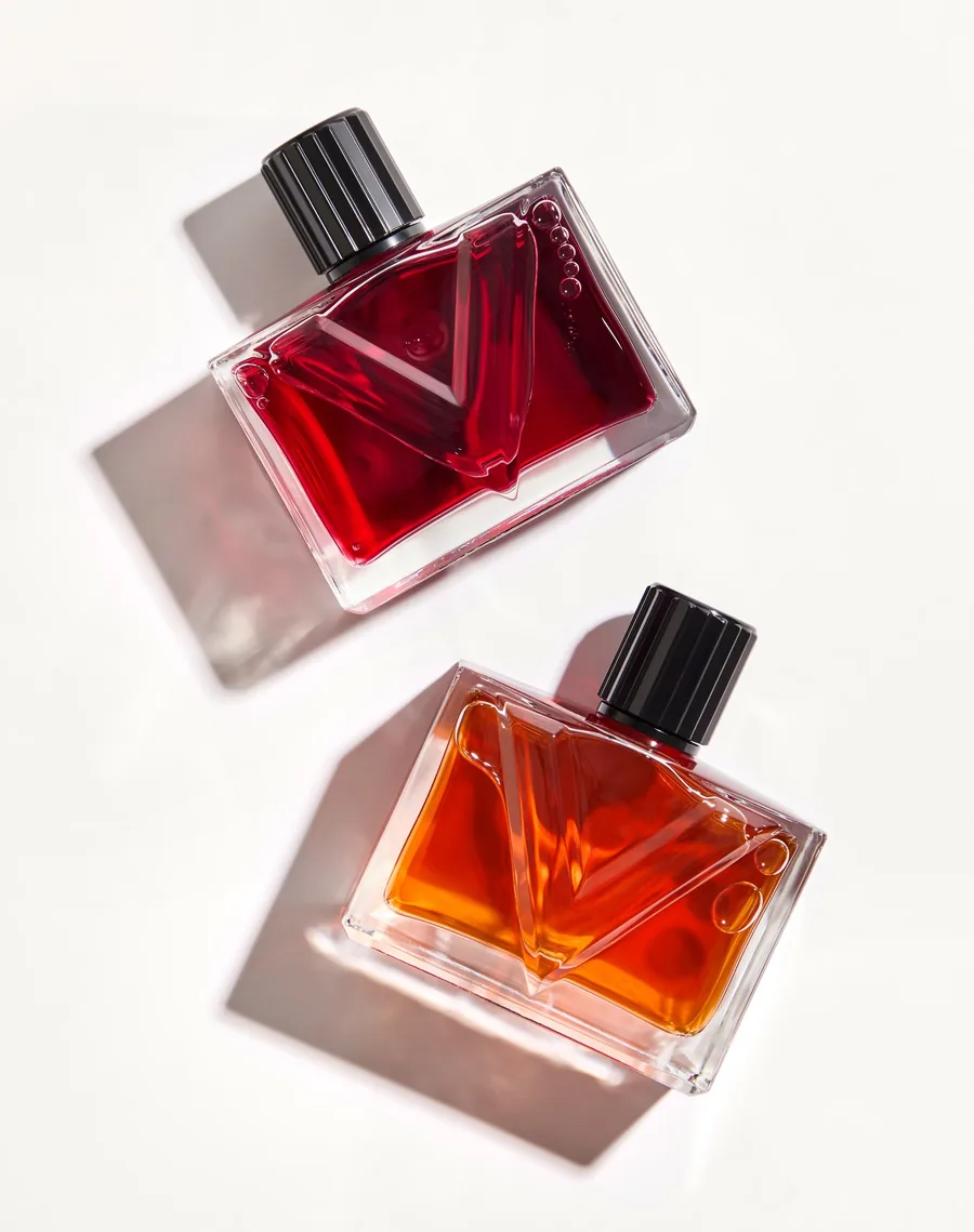 Valentino Vendetta: frasco de Vendetta Donna en rojo sobre el frasco de Vendetta Uomo en color coñac, sobre fondo claro