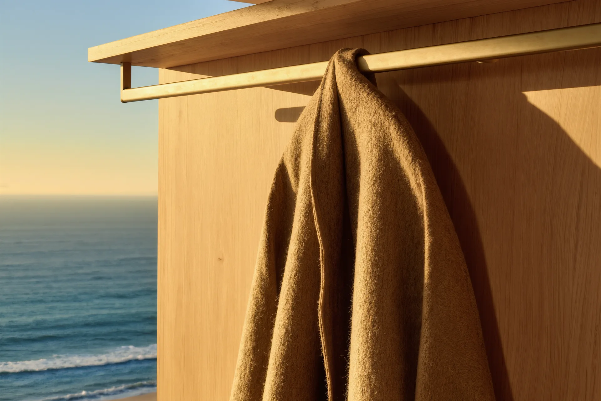 Detalle de un abrigo de lana artesanal colgado en un armario minimalista de madera clara