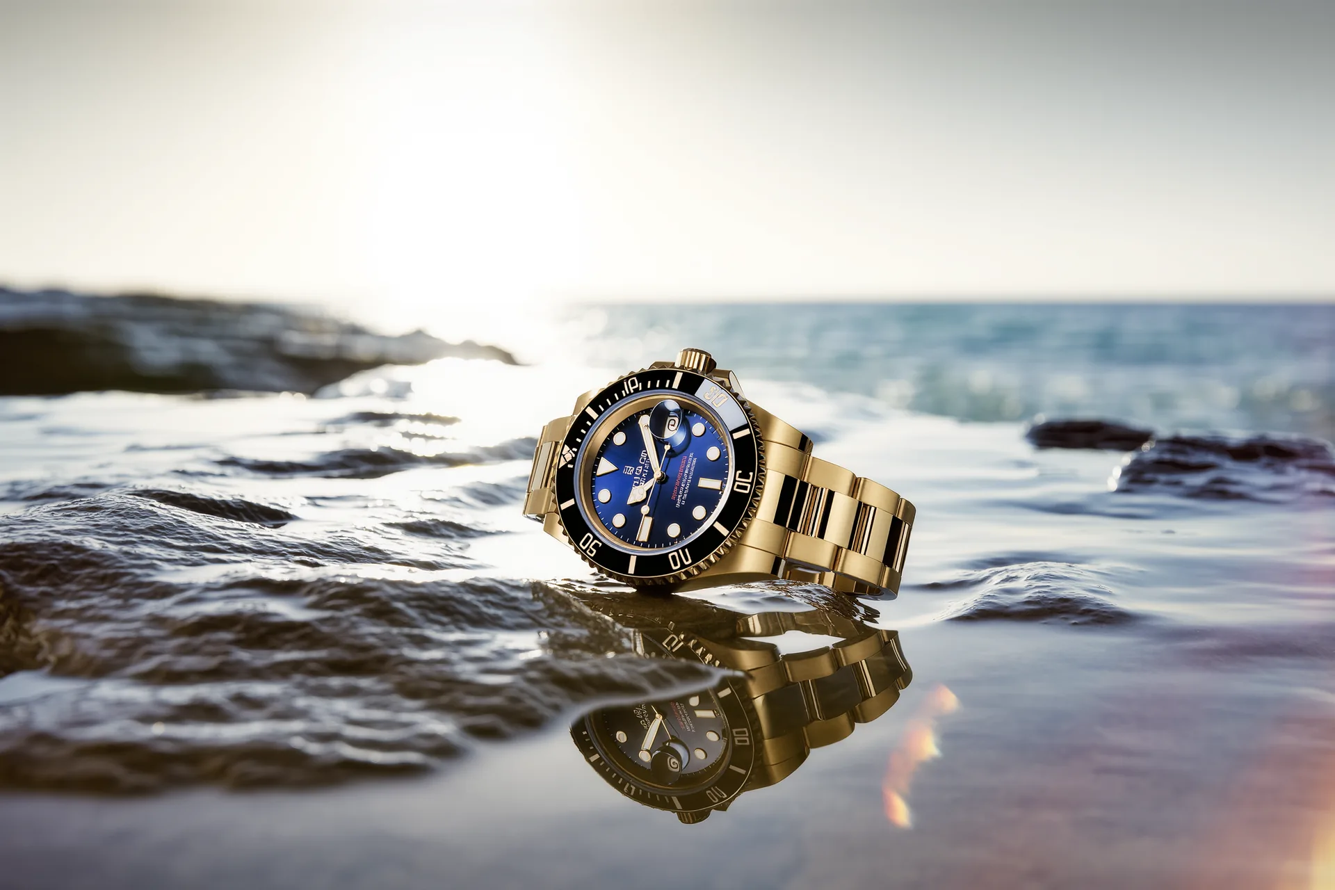 Reloj de buceo de acero con bisel unidireccional negro y esfera luminiscente fotografiado sobre roca húmeda junto al mar