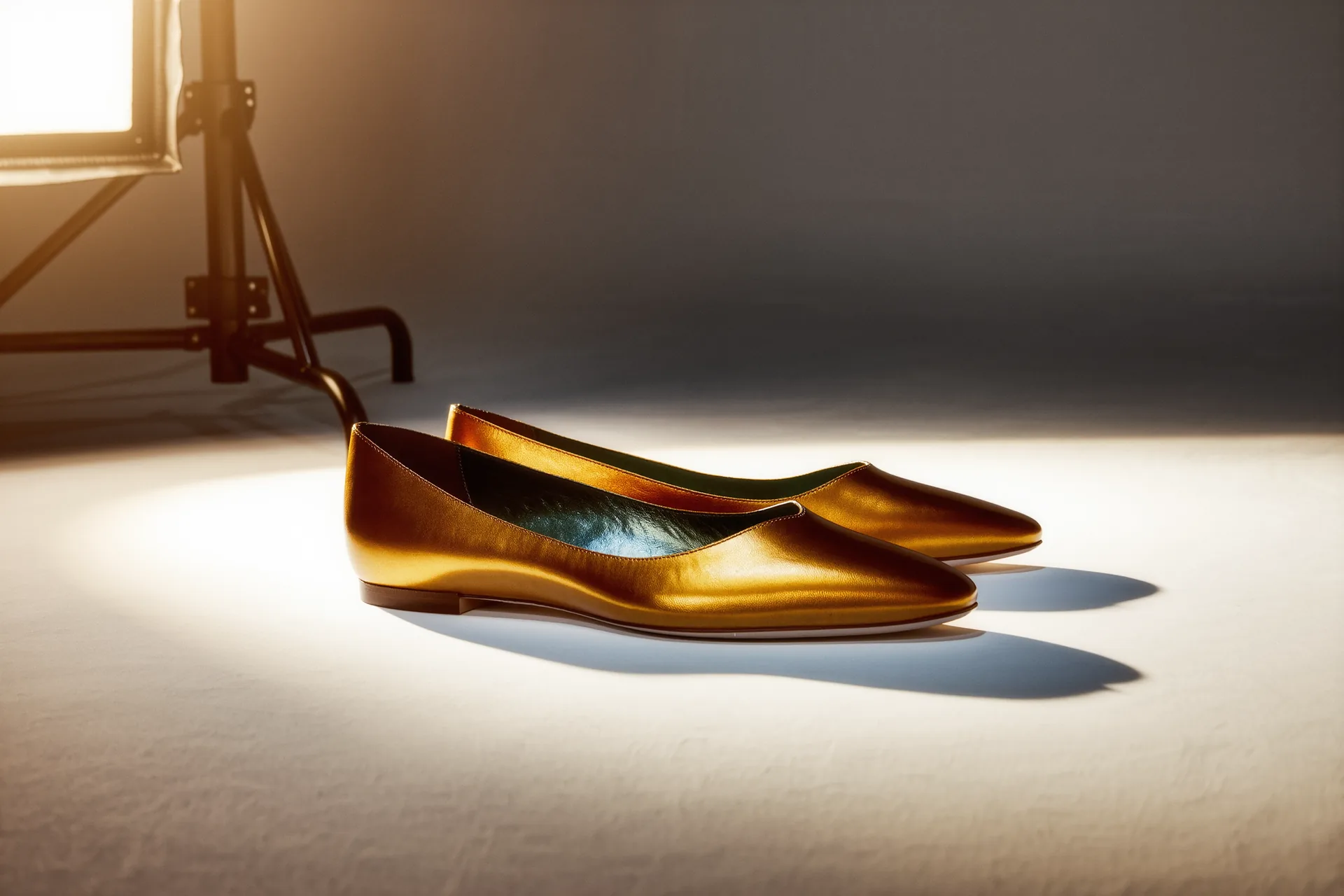 Zapatos de salón de piel en un estudio con luz cálida, mostrando el perfil del tacón y la puntera